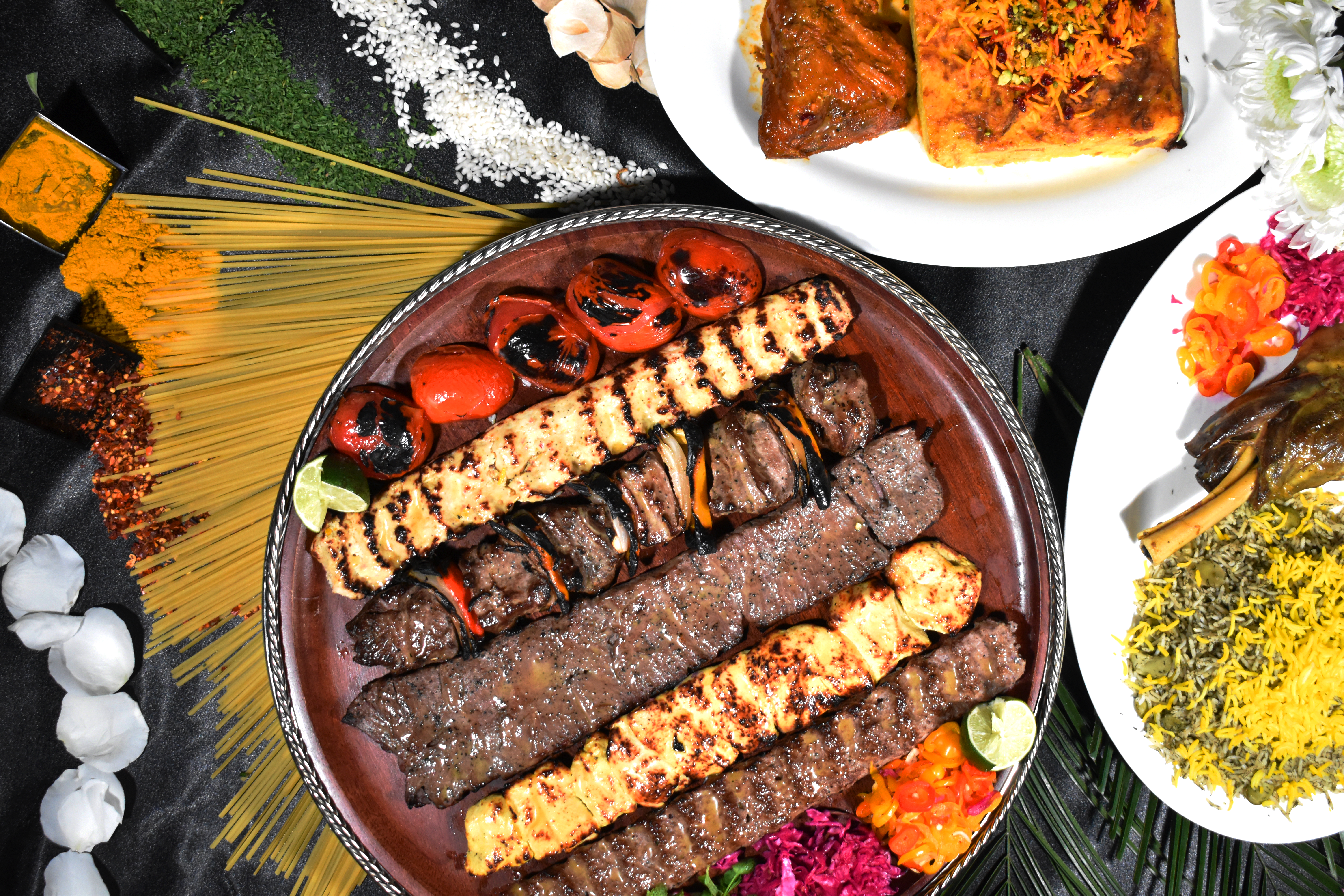 Chef plating a mixed grill of Persian kabobs with saffron rice